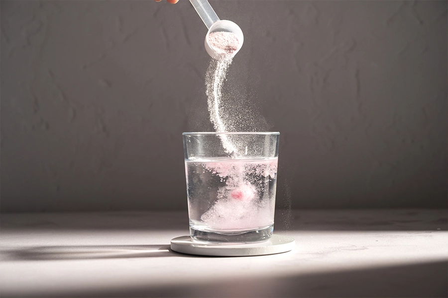 Pouring food supplement powder in glass of water. 